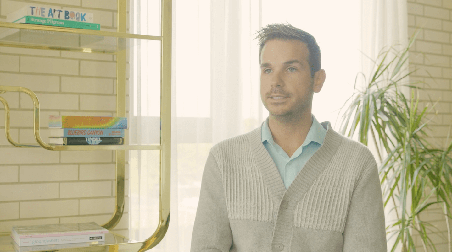 Jeremy Lawson of Fogelman Properties sits in a room with books and a plant in the background.